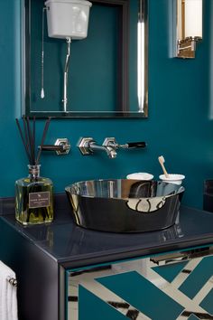 a bathroom with blue walls and black countertop, white sink and chrome faucet