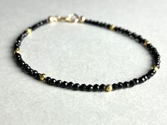 BLACK ONYX BRACELET WITH DELICATE GOLD DETAIL This pretty bracelet, made from Mini-Onyx-Beads has a length of 17.5cm.  Onyx Gemstone stands for inner strength and discipline ;) If you like another length, please specify when ordering I send all my jewelry packaged in a small cotton jewelry pouch. MATERIAL Onyx beads 2mm Gold Pyrite, coated 2mm Clasp-Gold filled Black Round Beads Jewelry For Friendship, Minimalist Black Beads Bracelets As Gift, Minimalist Black Beads Bracelet As Gift, Minimalist Black Beads Bracelet For Gift, Minimalist Black Bead Bracelets As Gift, Black Faceted Jewelry As A Gift, Dainty Black Beaded Bracelets For Gift, Black Faceted Jewelry For Gift, Handmade Black Jewelry For Friendship