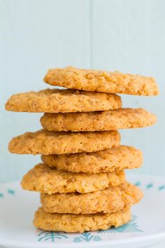 a stack of cookies sitting on top of a white plate in front of a fence