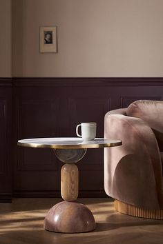 a coffee table with a cup on it next to a couch