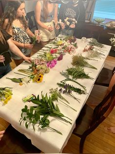 a group of people standing around a table with flowers on it