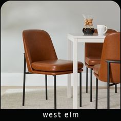 two brown leather chairs sitting next to a white table