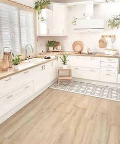 a kitchen with white cabinets and wooden floors