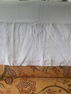 an embroidered pillow on top of a bed