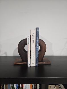 two books are placed on top of each other in front of a book shelf with several books