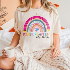 Celebrate the joy of teaching with our Custom Rainbow Shirt, perfect for kindergarten teachers! This vibrant, personalized back-to-school shirt adds a splash of color to your classroom and makes a delightful statement. Get ready to inspire young minds in style!   Hey, fabulous educators! Ready to transform your teaching wardrobe? Introducing our Custom Rainbow Shirt—where every color tells a story!  Imagine stepping into your classroom, radiating positivity and creativity! This isn’t just a shirt; it’s a vibrant canvas that showcases your unique style and passion for teaching. Personalize it to reflect your flair and let your personality shine brighter than a box of crayons!  Picture this: your students’ eyes lighting up as you don this cheerful masterpiece. Every day becomes a celebration Fifth Grade Math, Kindergarten Teacher Shirts, Kindergarten Shirts, Kindergarten Teacher, Rainbow Shirt, Kindergarten Teachers, Comfort Colors Tee, Shirt Collection, School Shirts