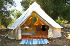 a white tent sitting in the middle of a forest