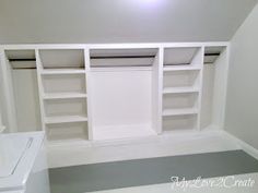 an empty room with white shelving and grey flooring