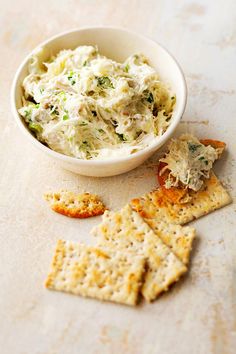 a bowl of food with crackers next to it