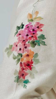 a white sweater with flowers painted on it