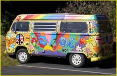 a colorful van is parked on the side of the road in front of some trees