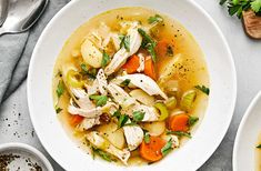 a bowl of chicken and vegetable soup on a table