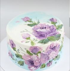 a white cake with purple flowers painted on it