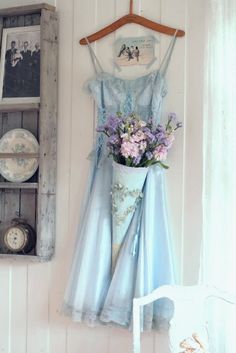 a dress hanging on a wall with flowers in it