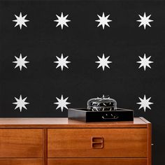 a black wall with white stars on it and an old phone sitting on the dresser