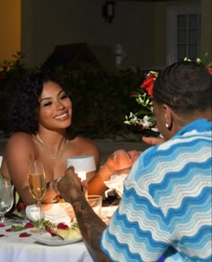 a man and woman sitting at a table with food