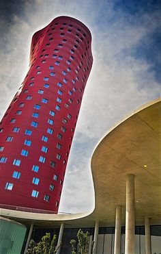 a tall red building sitting next to a parking lot