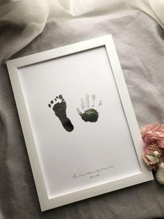 a baby's hand and foot print in a white frame