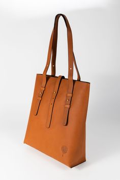 Meet the Cognac Eco-Leather Shoulder Bag. Featuring two leather adjustable straps for best possible fit and leather that is tanned and processed with plant-based materials and dyes versus hazardous chemicals like formaldehyde. Top opening has a zipper closure with a fold-over functioning accent tab. On the interior, you'll find a zippered pocket on the back side and one interior slip pocket large enough to fit a smartphone. The interior cotton lining is rust orange and matches the color of the l Leather Tote Shoulder Bag With Adjustable Straps, Leather Shoulder Bag Tote With Adjustable Straps, Everyday Leather Shoulder Bag With Adjustable Straps, Leather Shoulder Bag With Adjustable Straps For Everyday, Leather Bag With Adjustable Straps For Daily Use, Modern Leather Bags With Adjustable Straps, Modern Leather Bag With Adjustable Straps, Everyday Brown Shoulder Bag With Adjustable Straps, Rectangular Leather Shoulder Bag With Adjustable Straps