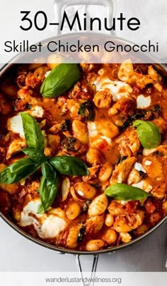 a skillet filled with chicken gnocchini and spinach leaves on top