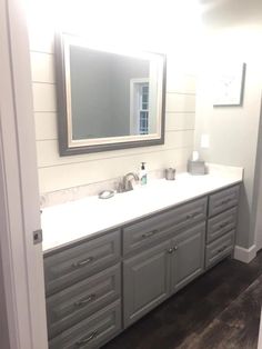 a bathroom with two sinks and a large mirror on the wall above it is shown