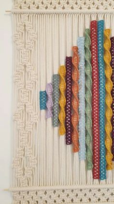 a group of different colored ribbons hanging on a wall next to a crochet doily