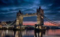 the tower bridge is lit up at night