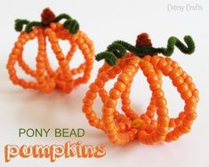 two orange beaded pumpkins sitting next to each other on a white surface with the words pony bead pumpkins written below them