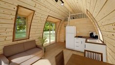 the interior of a tiny cabin with wood paneling and white appliances, including a couch