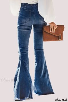 a woman in high rise jeans holding a brown purse