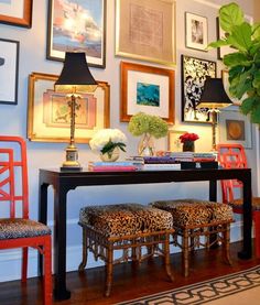 a table with two stools and some pictures on the wall