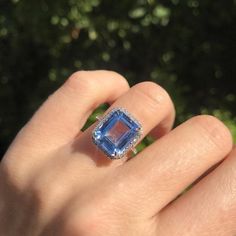 a woman's hand with a ring on it and a blue stone in the middle