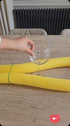 someone is holding a wine glass in front of some yellow sponges on a table