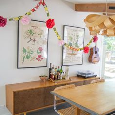 a dining room table and chairs with art on the wall