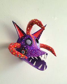 an animal mask hanging on the wall with polka dotty paint and sprinkles