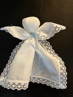 a white cloth with lace on it and a blue ribbon tied to the back of it