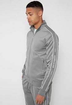 Attention to detail is at the core of Maniere De Voir’s premium tracksuits, with every hoodie and pair of jogging bottoms offering a comfortable fit, our signature branded components and wearable black, white and blue colourways. Explore the range of tracksuit sets, featuring pullover hoodies, joggers and lightweight track top vests. Whether you’re looking to achieve a sports luxe, smart casual or a relaxed aesthetic, our tracksuit designs fully encompass true off-duty style. Contemporary detail Sporty Outfits Men, Tracksuit Men, Relaxed Outfit, Tracksuit Jacket, Winter Outfits Men, Jogging Bottoms, Sports Luxe, Tracksuit Set