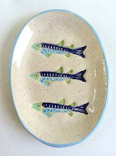 three small fish on a blue and white plate