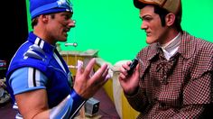 two men in costumes are talking to each other on the set of a television show