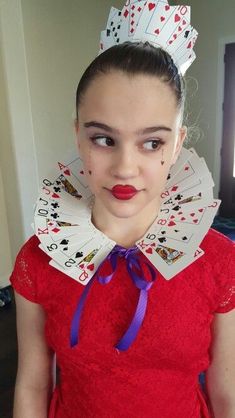 a woman in a red dress with cards on her neck and wearing a tiara