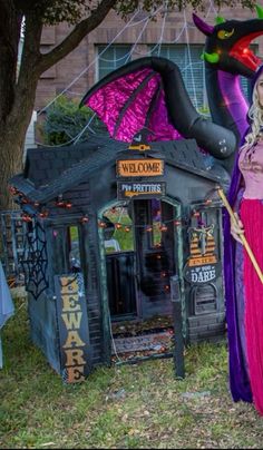 a woman dressed as a witch standing in front of a booth