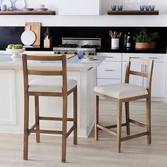 a kitchen with white cabinets and wooden stools