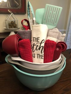 a bowl filled with kitchen items on top of a wooden table next to an oven mitt