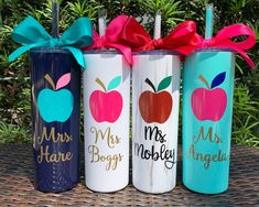 three personalized tumbles with bows on them are sitting next to each other in front of some bushes