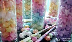 there are many different colored marshmallows in glass jars