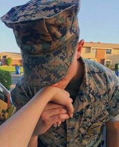 a soldier covering his face with another soldier's hand while holding the other hand