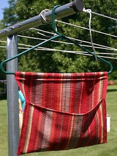 a red and white striped bag hanging from a clothes line with trees in the background