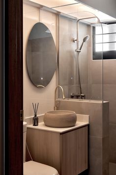 a bathroom with a sink, mirror and toilet in it's stall area next to a walk - in shower