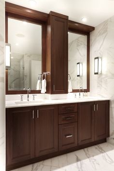 a bathroom with double sinks and large mirrors