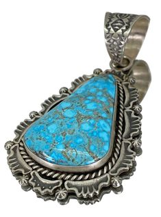 1 3/4" x 2 1/2" Bail: 3/4" Harold Joe's craftsmanship shines luminously in this sterling silver pendant! In symphony of sterling silver and vibrant color where each aspect harmonizes to create a piece of extraordinary allure, the Kingman Turquoise stone, known for its brilliant blue hue and earthy matrix, serves as a mesmerizing centerpiece. Surrounding it, the silverwork is an exhibition of Harold Joe's artistic prowess, featuring native floral designs, scalloped edges, and subtle textures that Elegant Pendant Turquoise Necklace Collectible, Elegant Turquoise Pendant Necklace Collectible, Elegant Turquoise Pendant Necklace, Elegant Turquoise Pendant Necklace With Large Stone, Southwestern Jewelry, Kingman Turquoise, Types Of Stones, Subtle Textures, Scalloped Edges